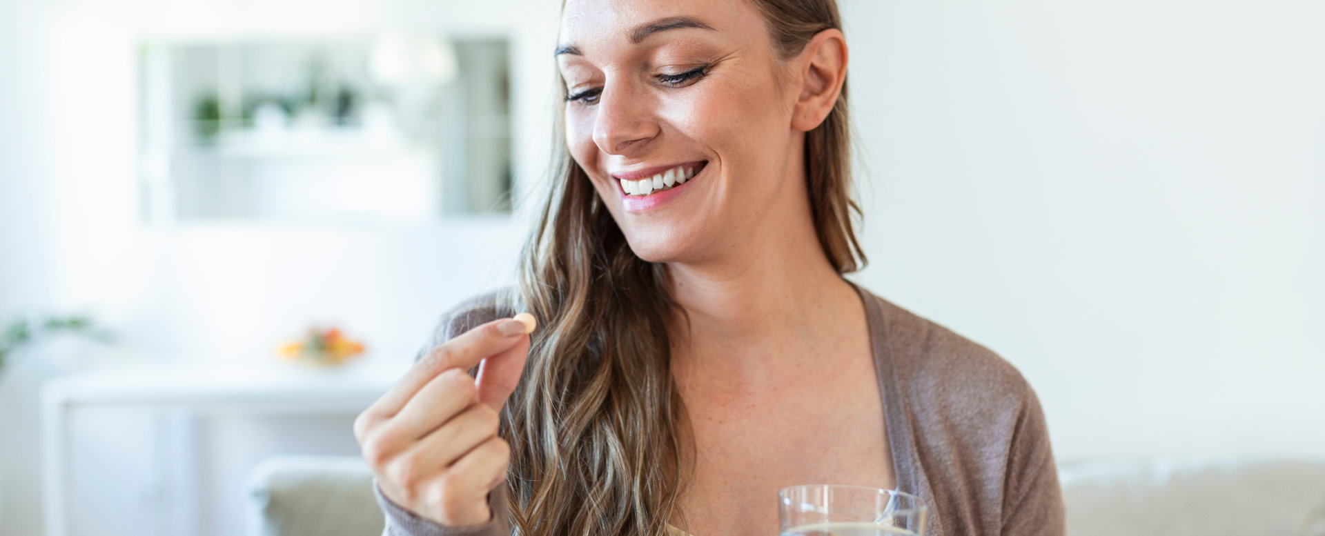 Head shot portrait happy woman holds pill glass of water