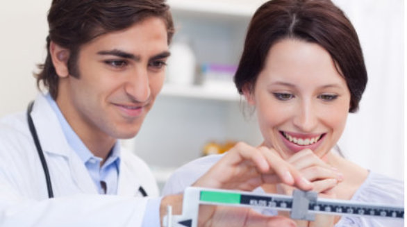 Young male doctor adjusting scale for his patient